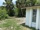 View of the exterior showing the side of the home next to a vacant lot, framed by lush greenery at 432 Olivia Rd, Venice, FL 34293