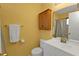 Well-lit bathroom with a single sink vanity, toilet, and a wood medicine cabinet at 5909 Talbrook Rd, North Port, FL 34287
