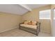 Small room features a neutral daybed with pillows and tile flooring and a small window at 5909 Talbrook Rd, North Port, FL 34287