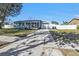 Single-story home with a light-blue exterior, fenced yard, and long driveway at 5909 Talbrook Rd, North Port, FL 34287