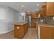 Bright kitchen featuring a center island, granite countertops, stainless steel refrigerator, and tiled backsplash at 5909 Talbrook Rd, North Port, FL 34287