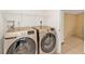 Laundry room features modern Samsung washer and dryer units, white walls, and tiled floor at 5909 Talbrook Rd, North Port, FL 34287
