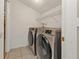 Laundry room features modern Samsung washer and dryer units, white walls, and tiled floor at 5909 Talbrook Rd, North Port, FL 34287