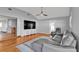 Open living room with wood floors, vaulted ceiling, modern furniture, and outdoor access at 5909 Talbrook Rd, North Port, FL 34287