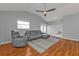 Living room features wood floors, vaulted ceiling, gray sofa, and a ceiling fan at 5909 Talbrook Rd, North Port, FL 34287