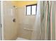 A bathroom shower featuring tiled walls and a window for natural light and ventilation at 5909 Talbrook Rd, North Port, FL 34287