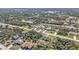 This is an aerial view of the neighborhood, with trees surrounding the community, and a lake in the background at 11338 Willmington Blvd, Port Charlotte, FL 33981