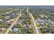 Aerial view of a home nestled in a lush, green neighborhood with access to nearby roads and waterways at 11338 Willmington Blvd, Port Charlotte, FL 33981