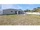 A spacious backyard featuring a screened lanai and patio with lawn chairs at 11338 Willmington Blvd, Port Charlotte, FL 33981