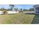 Large, grassy backyard with a white fence and seating area at 11338 Willmington Blvd, Port Charlotte, FL 33981