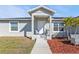 Inviting front porch with seating for relaxing, a manicured garden area and a well-maintained exterior at 11338 Willmington Blvd, Port Charlotte, FL 33981