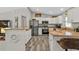 Bright kitchen featuring stainless steel appliances, white cabinets, granite countertops and wood-look flooring at 11338 Willmington Blvd, Port Charlotte, FL 33981