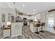 Open-concept kitchen with stainless steel appliances, white cabinetry, and a breakfast bar at 11338 Willmington Blvd, Port Charlotte, FL 33981