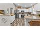 Well-lit kitchen featuring stainless steel appliances, granite countertops and wood-style flooring at 11338 Willmington Blvd, Port Charlotte, FL 33981