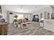 Spacious living room with light wood-style flooring, ceiling fan, and coastal decorations at 11338 Willmington Blvd, Port Charlotte, FL 33981