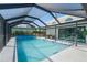 Inviting screened-in pool area featuring a summer kitchen and sliding doors to the home's interior at 1316 Monte Carlo Ct, Punta Gorda, FL 33950