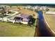Aerial view of a single-story home with waterfront views, solar panels, and lush landscaping on a sunny day at 17122 Barcrest Ln, Punta Gorda, FL 33955