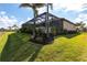 Well-manicured backyard featuring tropical landscaping and screened-in lanai with pool at 17122 Barcrest Ln, Punta Gorda, FL 33955