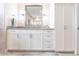 Bathroom vanity with white cabinetry, marble countertop, modern fixtures, and large mirror providing ample storage at 17122 Barcrest Ln, Punta Gorda, FL 33955
