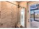 Close-up of the glass-enclosed walk-in shower with stone accents and an exterior view at 17122 Barcrest Ln, Punta Gorda, FL 33955