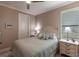Comfortable bedroom with a full size bed, neutral color walls, ceiling fan, and bright natural lighting from the window at 17122 Barcrest Ln, Punta Gorda, FL 33955