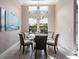 Bright dining room features modern light fixture, large windows, and seating for six at 17122 Barcrest Ln, Punta Gorda, FL 33955