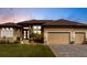 Charming, single-story home with a well-manicured lawn, paved driveway, and a two-car garage at sunset at 17122 Barcrest Ln, Punta Gorda, FL 33955