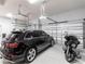 Well-organized garage with a black SUV, a motorcycle and epoxy floors, offering ample parking and storage at 17122 Barcrest Ln, Punta Gorda, FL 33955