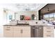 Kitchen island sink with stainless dishwasher, granite counters, and view to outdoor living space at 17122 Barcrest Ln, Punta Gorda, FL 33955