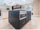 Close up of kitchen island featuring cabinets, drawers, stainless steel microwave, and granite counters at 17122 Barcrest Ln, Punta Gorda, FL 33955