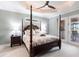 Main bedroom features a four-poster bed, tray ceiling, ceiling fan, and carpeted floors at 17122 Barcrest Ln, Punta Gorda, FL 33955