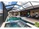 Screened-in pool and outdoor living area with kitchen featuring ample seating at 17122 Barcrest Ln, Punta Gorda, FL 33955
