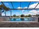 Beautiful pool showcasing cascading water features and a lovely view of the blue sky and distant trees at 17122 Barcrest Ln, Punta Gorda, FL 33955