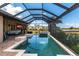 Screened-in pool and outdoor living area with view of the water and new construction at 17122 Barcrest Ln, Punta Gorda, FL 33955
