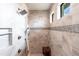 Neutral tiled walk-in shower with multiple shower heads, built-in niche, and window for natural light at 17122 Barcrest Ln, Punta Gorda, FL 33955