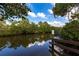 Scenic waterfront view with trees reflected on the water with blue skies and white clouds above at 17122 Barcrest Ln, Punta Gorda, FL 33955