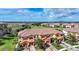 A stunning aerial view of a townhome community, featuring a tile roof, landscaping, and lake views at 20272 Lagente, Venice, FL 34293