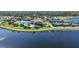 Stunning aerial view of community with a large pool, clubhouse, and tennis courts near a lake at 20272 Lagente, Venice, FL 34293