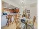 A dining area features a glass table, rattan chairs, and modern chandelier, complemented by an open kitchen layout at 20272 Lagente, Venice, FL 34293