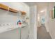 Bright laundry area features a full-size washer, dryer, and shelving for ample storage space at 20272 Lagente, Venice, FL 34293
