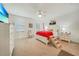Bright main bedroom featuring white furniture, neutral carpet, ceiling fan, and a bed with red accents at 20272 Lagente, Venice, FL 34293