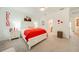 Bright main bedroom with a bed dressed in red, white furniture, ceiling fan, and warm neutral carpet at 20272 Lagente, Venice, FL 34293