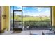 The screened patio features a lovely view of the golf course with comfortable seating and lush landscaping at 20272 Lagente, Venice, FL 34293