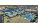 Aerial view showcasing the community's tennis and pickleball courts surrounded by lush landscaping at 20272 Lagente, Venice, FL 34293