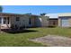 A view of the backyard features a covered patio, grassy area, and a storage shed at 21456 Holdern Ave, Port Charlotte, FL 33952