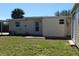 Backyard view showcases well-maintained lawn, exterior door, and a glimpse of the house's structure at 21456 Holdern Ave, Port Charlotte, FL 33952