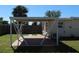 View of the backyard with a covered patio and a wooden fence in the background on a sunny day at 21456 Holdern Ave, Port Charlotte, FL 33952