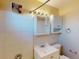 Bathroom featuring a shower with tile, medicine cabinet, sink, toilet, and storage cabinet at 21456 Holdern Ave, Port Charlotte, FL 33952
