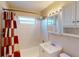 Bright bathroom with a bathtub, tiled wall, shower head, vanity, and window at 21456 Holdern Ave, Port Charlotte, FL 33952