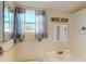 Bathroom featuring a single sink vanity and window with gray curtains at 21456 Holdern Ave, Port Charlotte, FL 33952